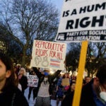 FILE - Tripp Hopkins, center, attends a rally to protest the news that the U.S. Supreme Court could be poised to overturn the landmark Roe v. Wade case that legalized abortion nationwide, May 3, 2022, at the Statehouse in Providence, R.I.