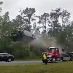 A vehicle goes airborne after driving up the ramp of a flatbed tow truck on a Georgia highway,