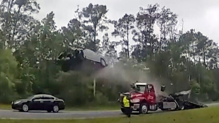 A vehicle goes airborne after driving up the ramp of a flatbed tow truck on a Georgia highway,