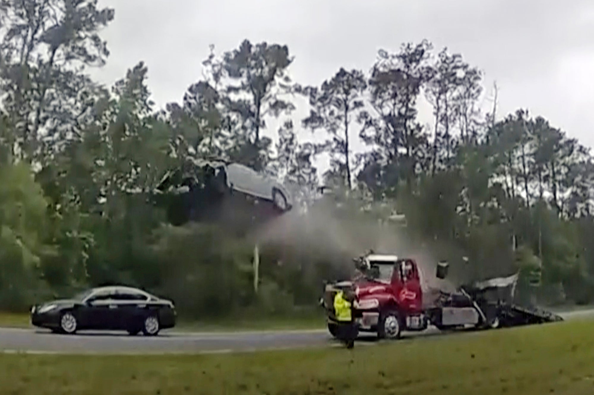 A vehicle goes airborne after driving up the ramp of a flatbed tow truck on a Georgia highway,