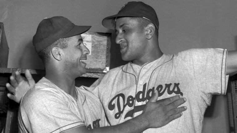 Brooklyn Dodgers catcher Roy Campanella, left, congratulates his battery mate, Don Newcombe, in the dressing room at the Polo Grounds in New York on Sept. 2, 1949.