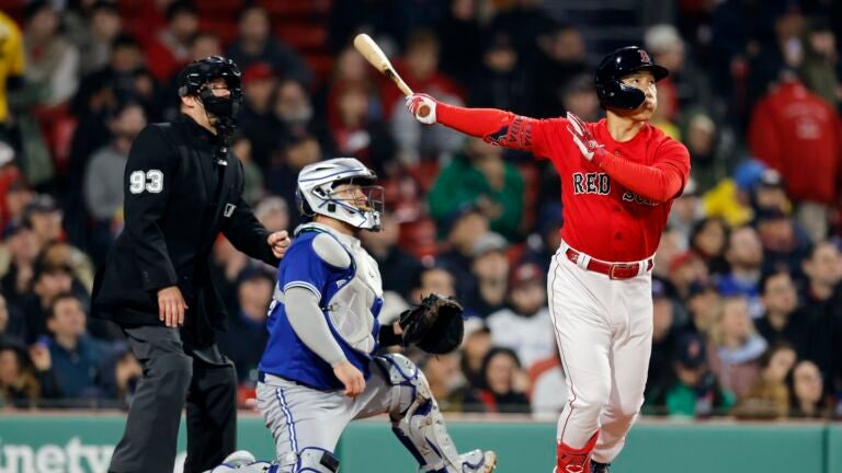Boston Red Sox's Masataka Yoshida flies out in front of Toronto Blue Jays' Alejandro Kirk during the third inning of a baseball game, Wednesday, May 3, 2023, in Boston.