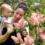 Boston weather -- Waltham holds her 9 month old son Grayson so he could better see the lilacs in bloom at Arnold Arboretum.