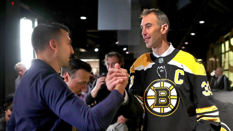 Boston Bruins Patrice Bergeron(left) congratulates Bruins Zdeno Chara after Chara held a press conference at TD Garden to announce his retirement after he signed a one-day contract with the team to retire form the Bruins and the NHL.