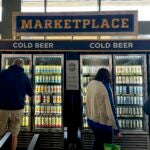 Fans look at a refrigerator full of beer at a Brewers game.