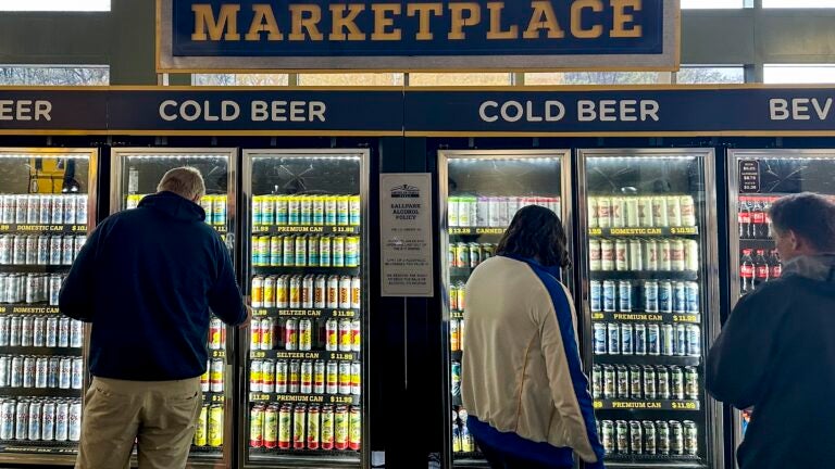 Fans look at a refrigerator full of beer at a Brewers game.