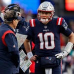 New England Patriots quarterback Mac Jones (10) talks with head coach Bill Belichick during the second half of an NFL football game, Sunday, Jan. 1, 2023, in Foxborough, Mass.