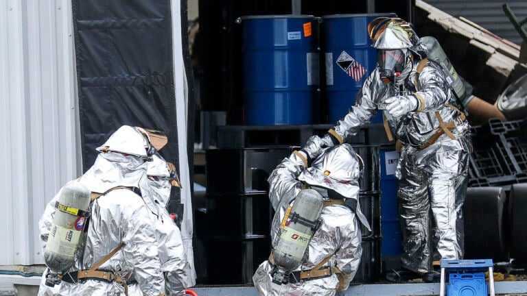 A hazmat team carefully removes barrels from an explosion site in Newburyport, Mass., Thursday, May 4, 2023.