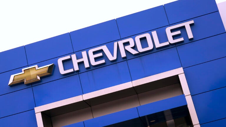 The Chevrolet logo is displayed on the facade of a dealership , Tuesday, Aug. 3, 2021, in Woburn, Mass.