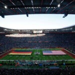 The German and United States flags are displayed on the field during the singing of the national anthem before an NFL football game between the Tampa Bay Buccaneers and the Seattle Seahawks at Allianz Arena in Munich, Germany, Sunday, Nov. 13, 2022. The Tampa Bay Buccaneers defeated the Seattle Seahawks 21-16.