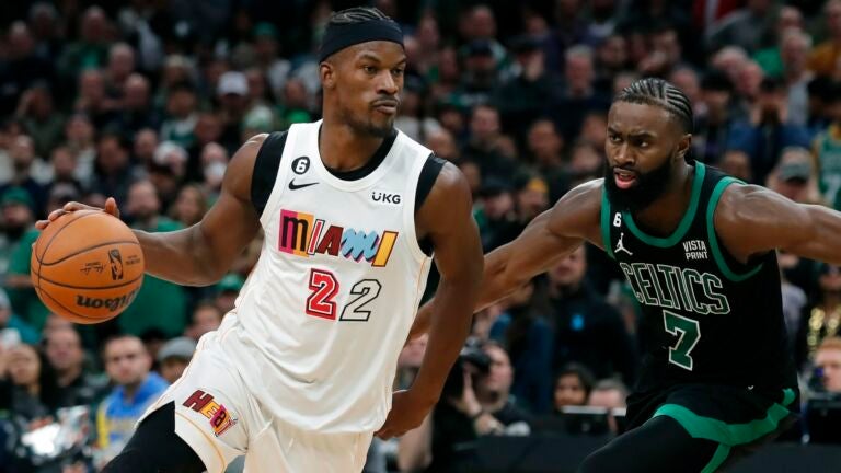 Miami Heat's Jimmy Butler (22) drives past Boston Celtics' Jaylen Brown (7) in overtime during an NBA basketball game, Friday, Dec. 2, 2022, in Boston.