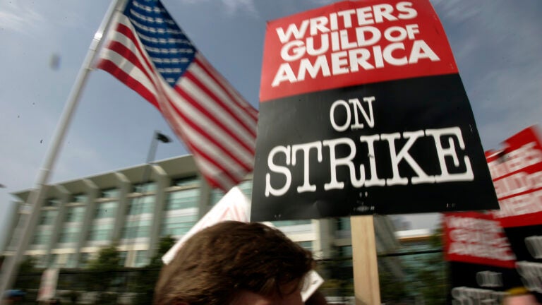 FILE - Writers Guild of America (WGA) writers and others strike against the Alliance of Motion Picture and Television Producers (AMPTP) in a rally at Fox Plaza in Los Angeles' Century City district