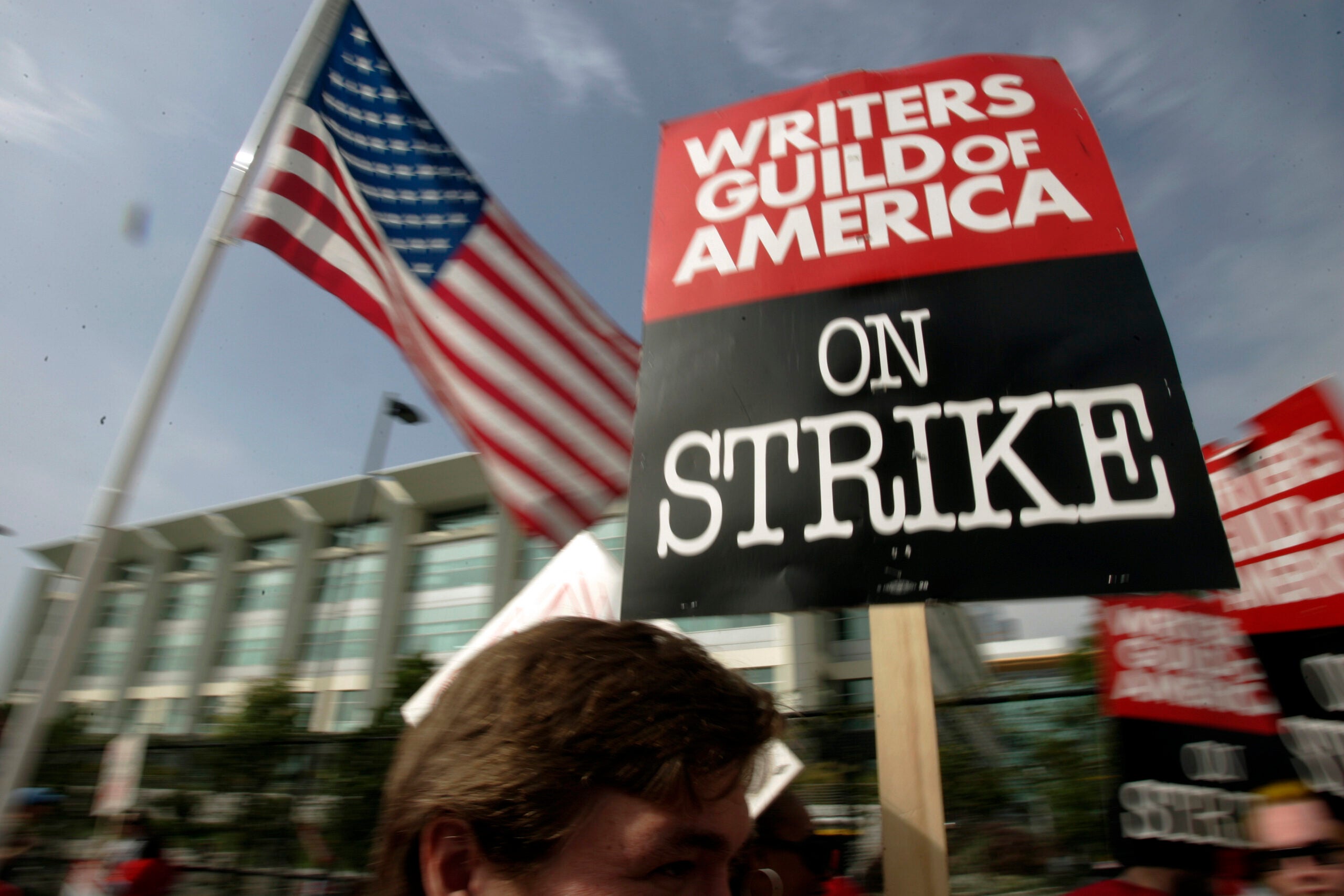 FILE - Writers Guild of America (WGA) writers and others strike against the Alliance of Motion Picture and Television Producers (AMPTP) in a rally at Fox Plaza in Los Angeles' Century City district