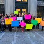 A group of students and community members hold up signs pushing for Lunar New Year to be added as a school holiday