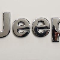 FILE - This is the Jeep logo on the front end of a Jeep Cherokee on display at the Pittsburgh International Auto Show in Pittsburgh Thursday, Feb. 11, 2016. Stellantis is telling owners of nearly 220,000 Jeep Cherokee SUVs worldwide, Tuesday, May 16, 2023, to park them outdoors and away from other vehicles because the power liftgates can catch fire even when the engines are off. The company is recalling certain Jeep Cherokees from the 2014 through 2016 model years. (AP Photo/Gene J. Puskar, File)
