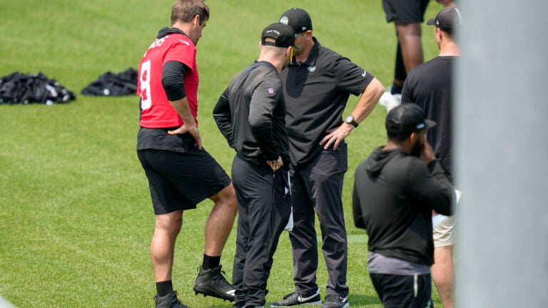 Jets quarterback Aaron Rodgers speaks with team personnel.