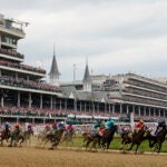 Horses come through the first turn during the 149th running of the Kentucky Derby horse race at Churchill Downs in Louisville, Ky.