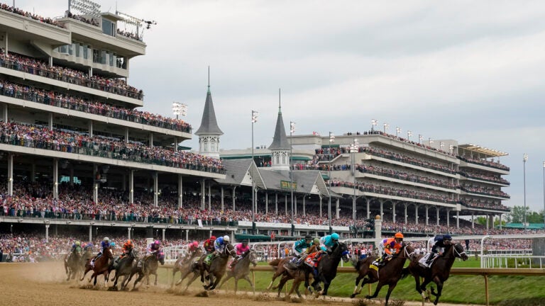 Horses come through the first turn during the 149th running of the Kentucky Derby horse race at Churchill Downs in Louisville, Ky.