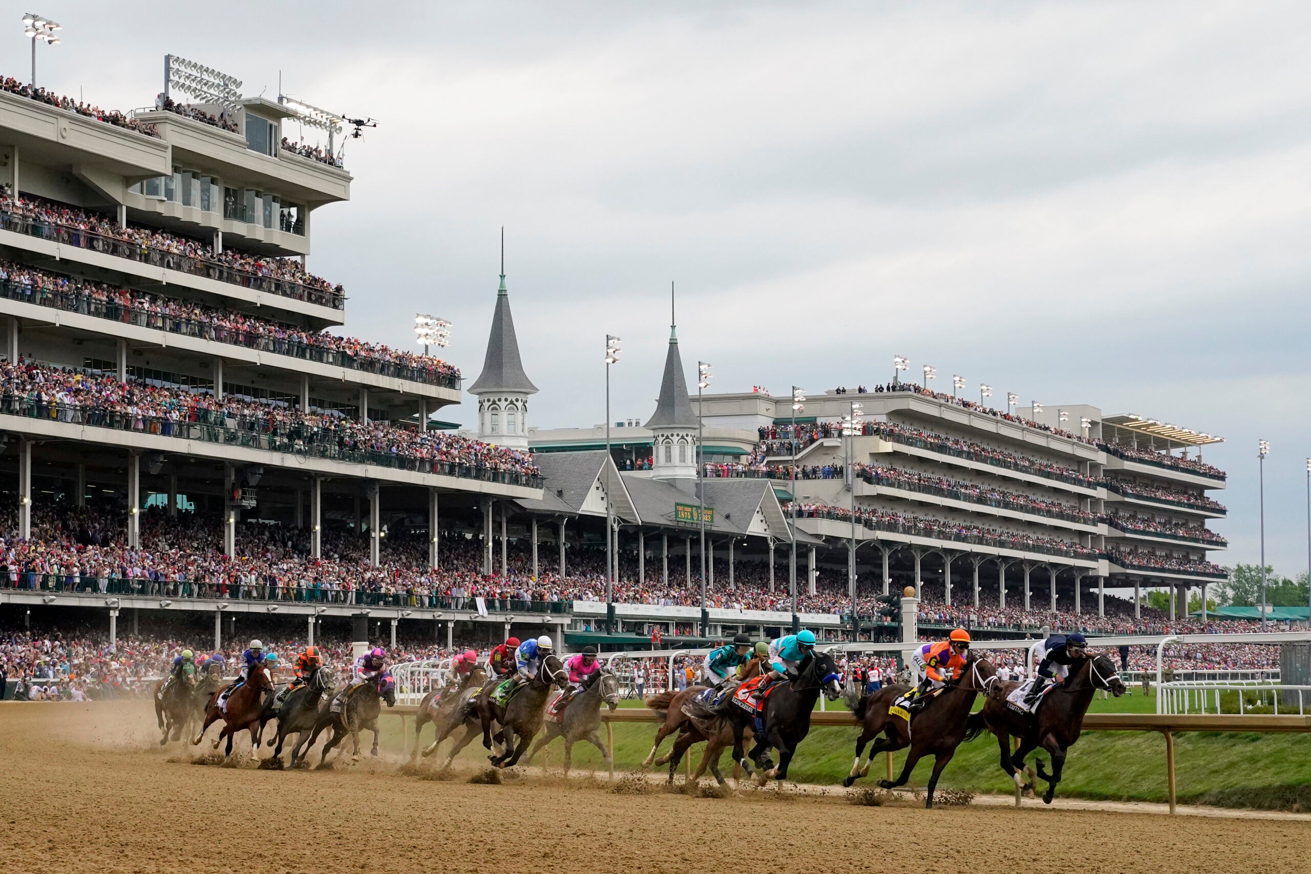 Horses come through the first turn during the 149th running of the Kentucky Derby horse race at Churchill Downs in Louisville, Ky.