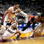 Miami Heat guard Gabe Vincent, left, fights for possession of the ball with New York Knicks guard RJ Barrett, second from right, during the first half of Game 4.