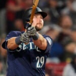 Seattle Mariners' Cal Raleigh watches the flight of his two-run home run against the Red Sox.