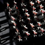 alt = People look at a display of wooden crosses and a Star of David on display at the Clark County Government Center in Las Vegas in 2018.