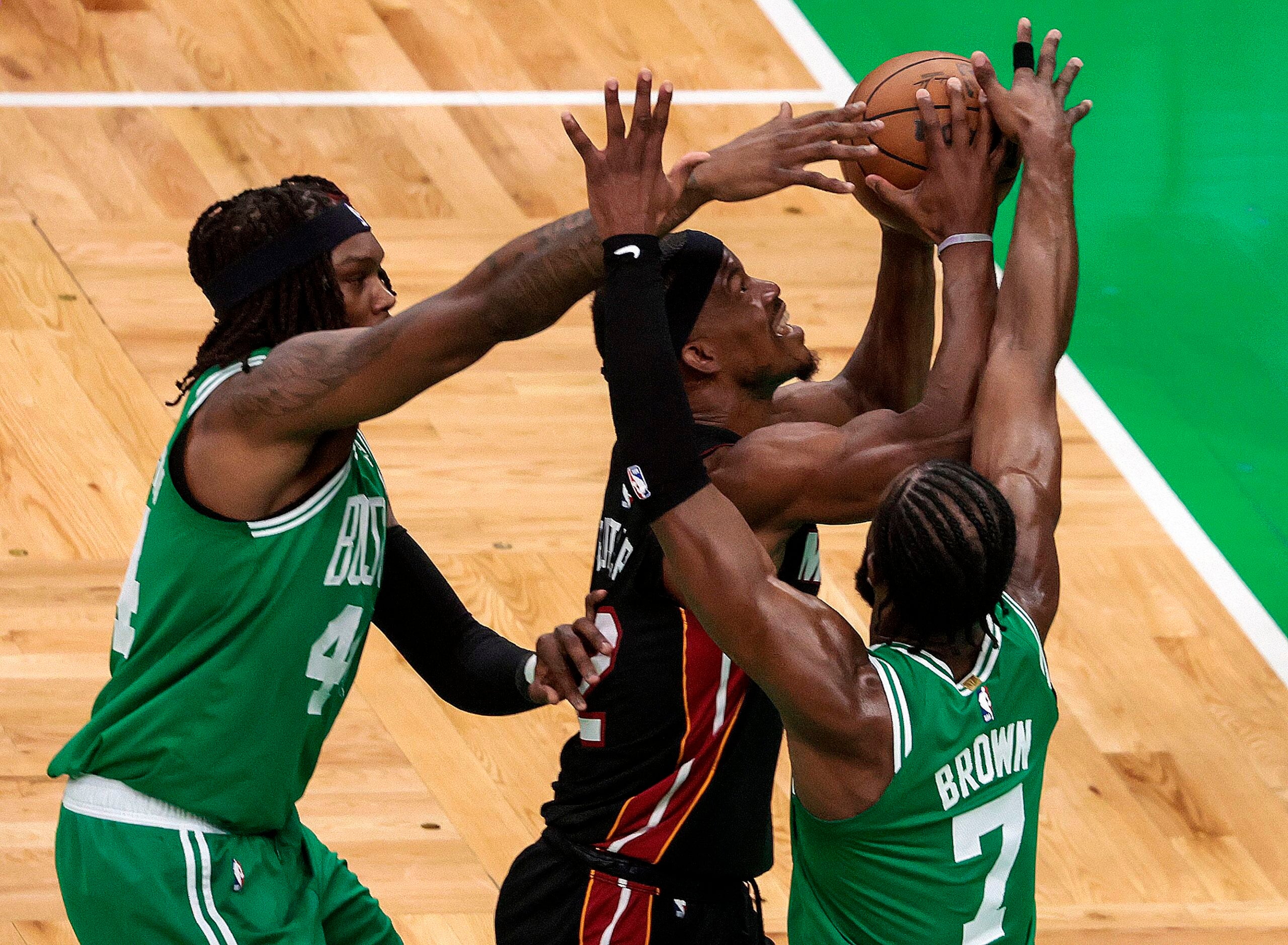 Celtics Robert Williams, Jaylen Brown, and Miami's Jimmy Butler battled for a loose ball during Game 7 Monday.