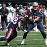 New England Patriots quarterback Mac Jones, right, hands off to James White during the first half of an NFL football game against the New York Jets, Sunday, Sept. 19, 2021, in East Rutherford, N.J.