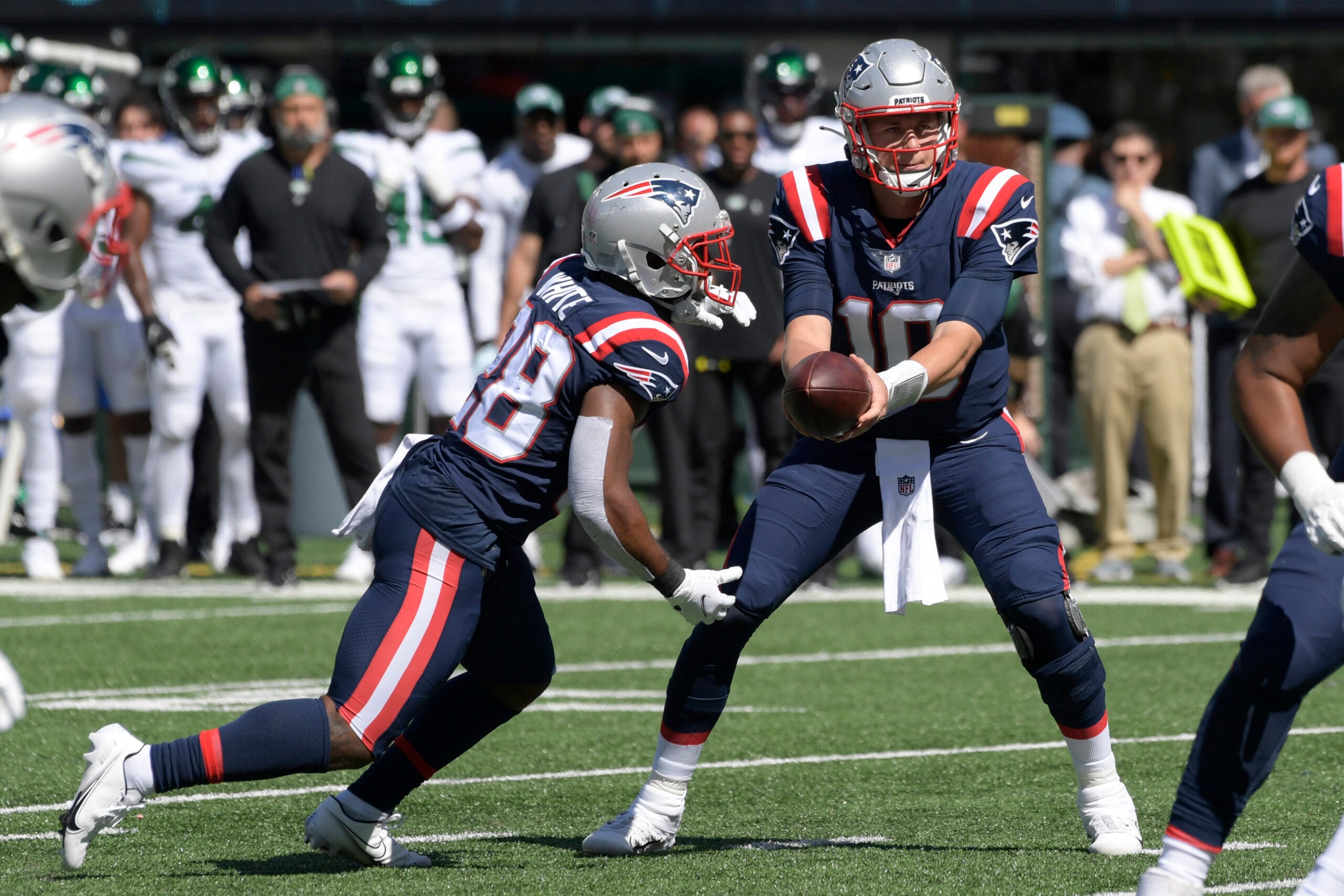New England Patriots quarterback Mac Jones, right, hands off to James White during the first half of an NFL football game against the New York Jets, Sunday, Sept. 19, 2021, in East Rutherford, N.J.
