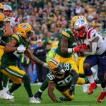 New England Patriots Rhamondre Stevenson breaks away from Green Bay Packers Darnell Savage during fourth quarter NFL action at Lambeau Field.