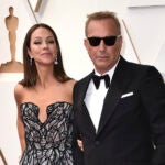 Christine Baumgartner, left, and Kevin Costner arrive at the Oscars, March 27, 2022, at the Dolby Theatre in Los Angeles.