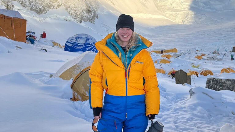 Rebecca Long wears a bright yellow jacket and blue pants on Mount Everest