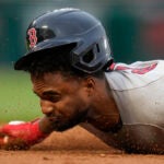 Pablo Reyes grimaces up close as he dives back into first base.