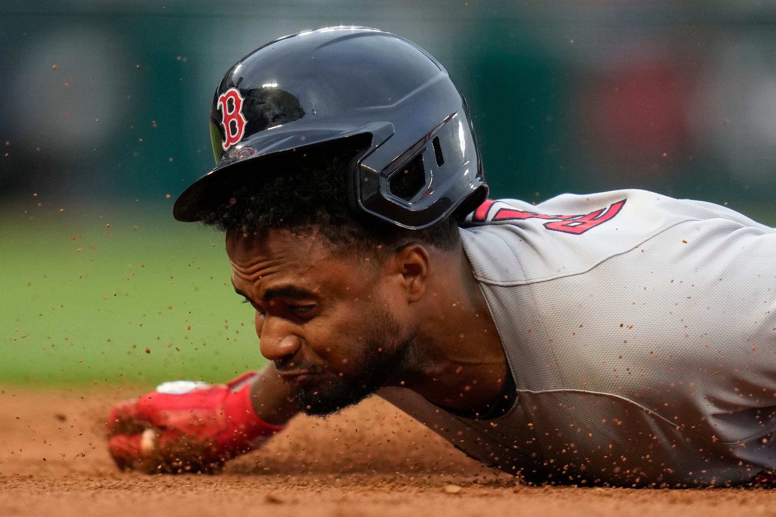 Pablo Reyes grimaces up close as he dives back into first base.