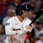 Red Sox third baseman Rafael Devers looks down the line after hitting a ball in a game against the Cardinals.