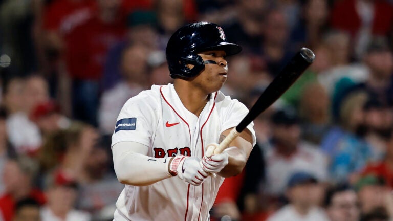 Red Sox third baseman Rafael Devers looks down the line after hitting a ball in a game against the Cardinals.