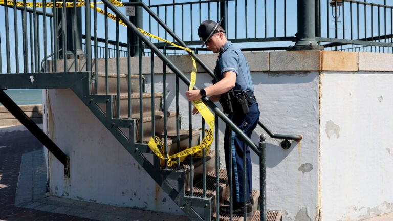 A State trooper puts up yellow tape on the Revere Beach bandstand.