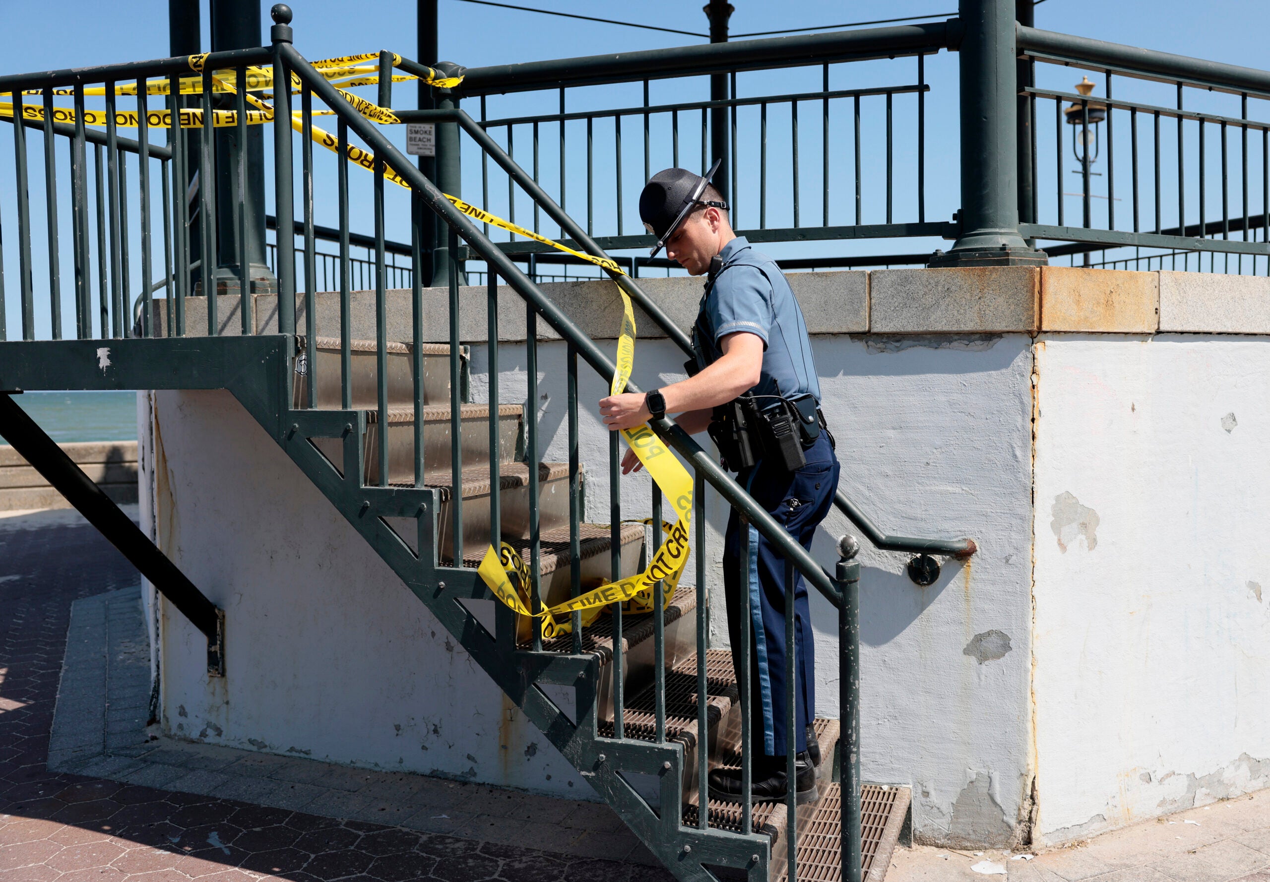 A State trooper puts up yellow tape on the Revere Beach bandstand.