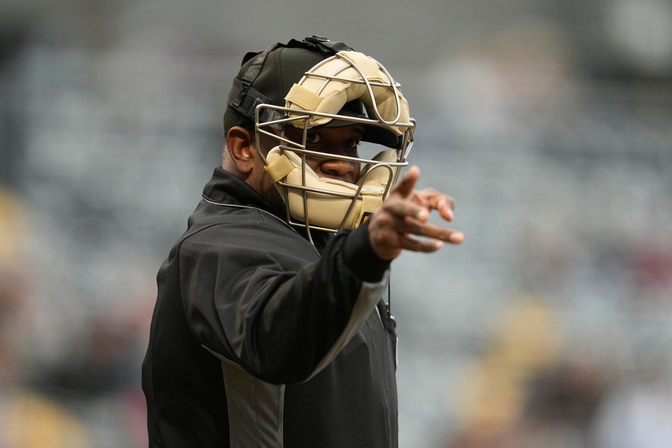 An umpire signals for a strike after being told a strike call through an earpiece during the first inning of a minor league baseball game between the St. Paul Saints and the Nashville Sounds.