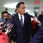 Senator Mitt Romney surrounded by reporters