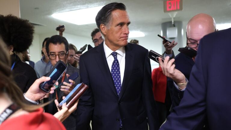 Senator Mitt Romney surrounded by reporters