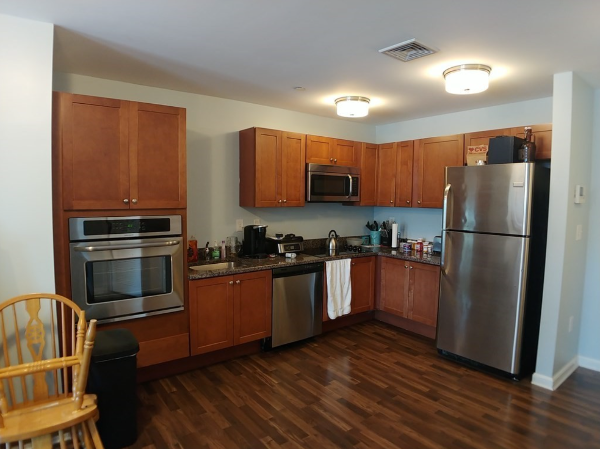 Kitchen with Shaker-style cabinetry, stainless steel appliances, and hardwood floors.