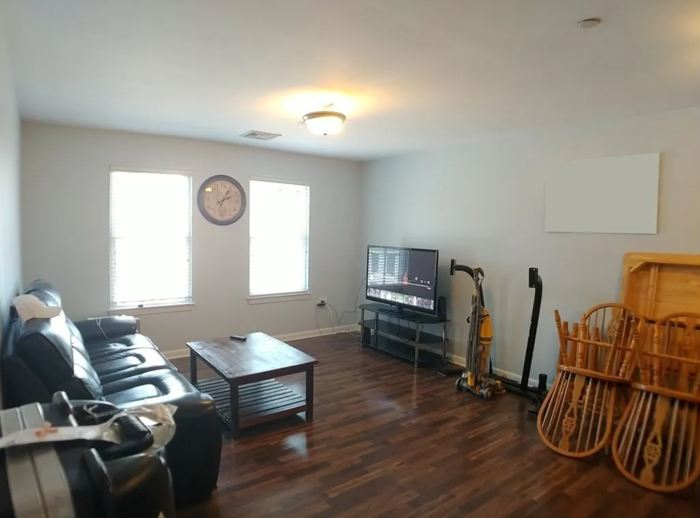 Living room with beige walls, hardwood floors, and single-hung windows.