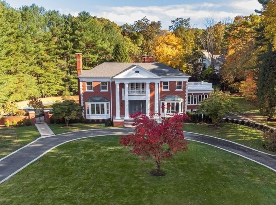 Red brick colonial surrounded by trees on 2.85-acre lot.