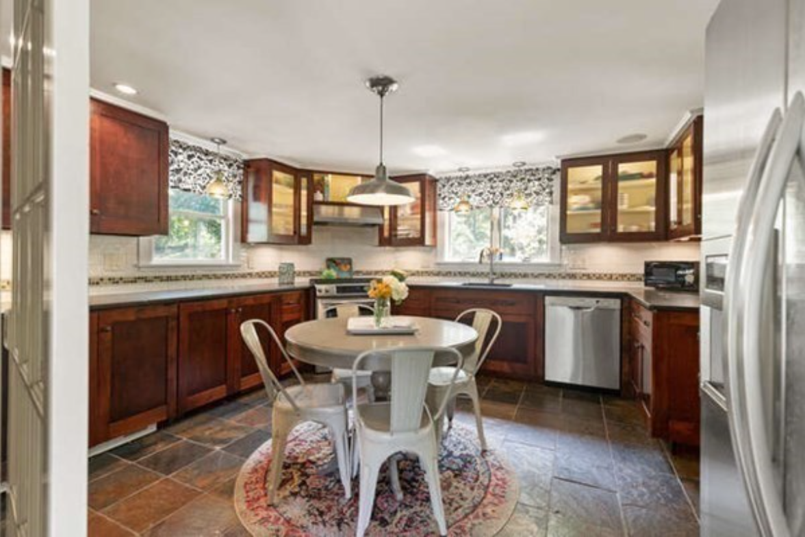 Kitchen with stainless steel appliances, pendant lighting, and hardwood floors.