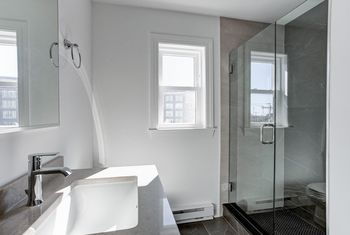 Bathroom with single-hung window, walk-in shower, and single vanity.
