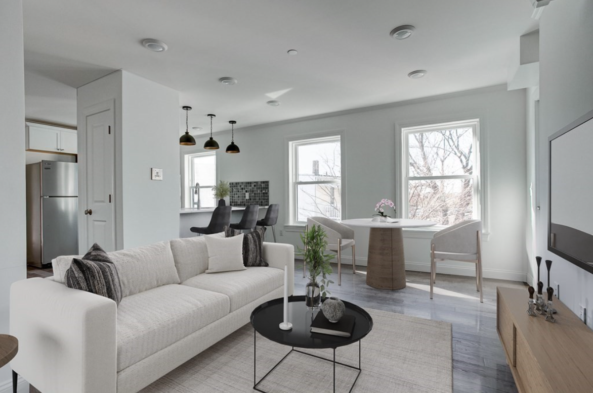 Living room with light gray walls, hardwood floors and single-hung windows.