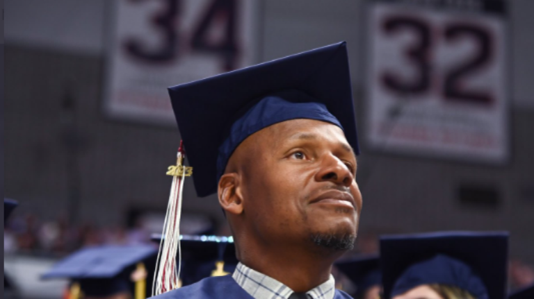 NBA Hall of Famer Ray Allen sits in the Gampel Pavillion underneath his reitred No. 34 jersey.
