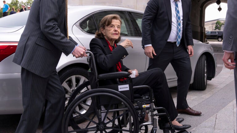 FILE - Sen. Dianne Feinstein, D-Calif., is assisted to a wheelchair by staff as she returns to the Senate after a more than two-month absence