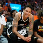 Phoenix Mercury center Brittney Griner smiles at the fans as she sits between Mercury's Shey Peddy, left, and Evina Westbrook, right.